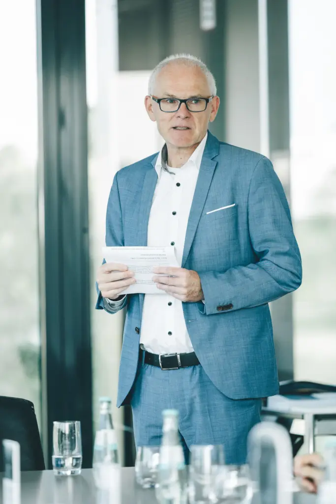 Älterer Mann im Anzug bei Präsentation