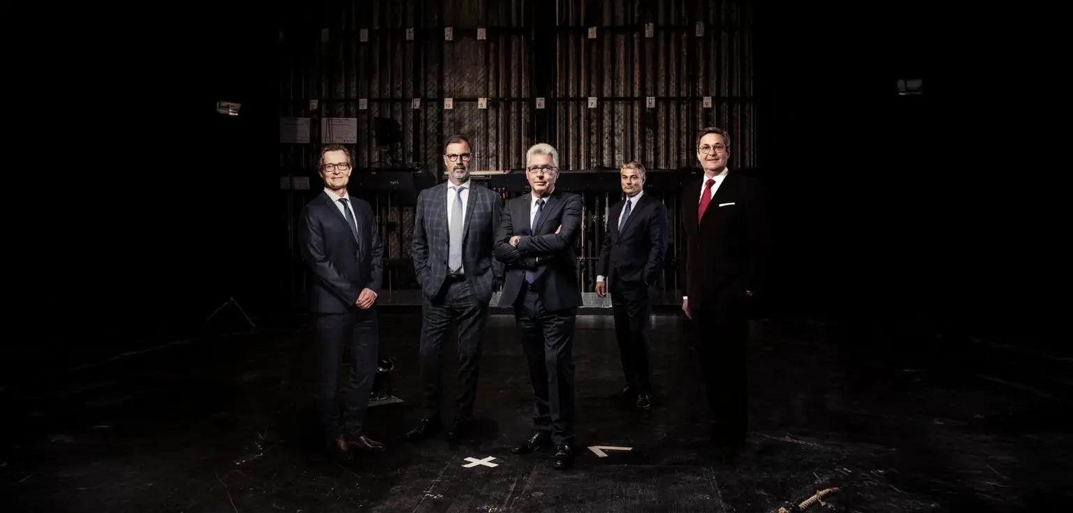 Fünf Personen vor einer Theaterbühne