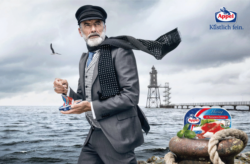 Mann mit Heringdose am Wasser.