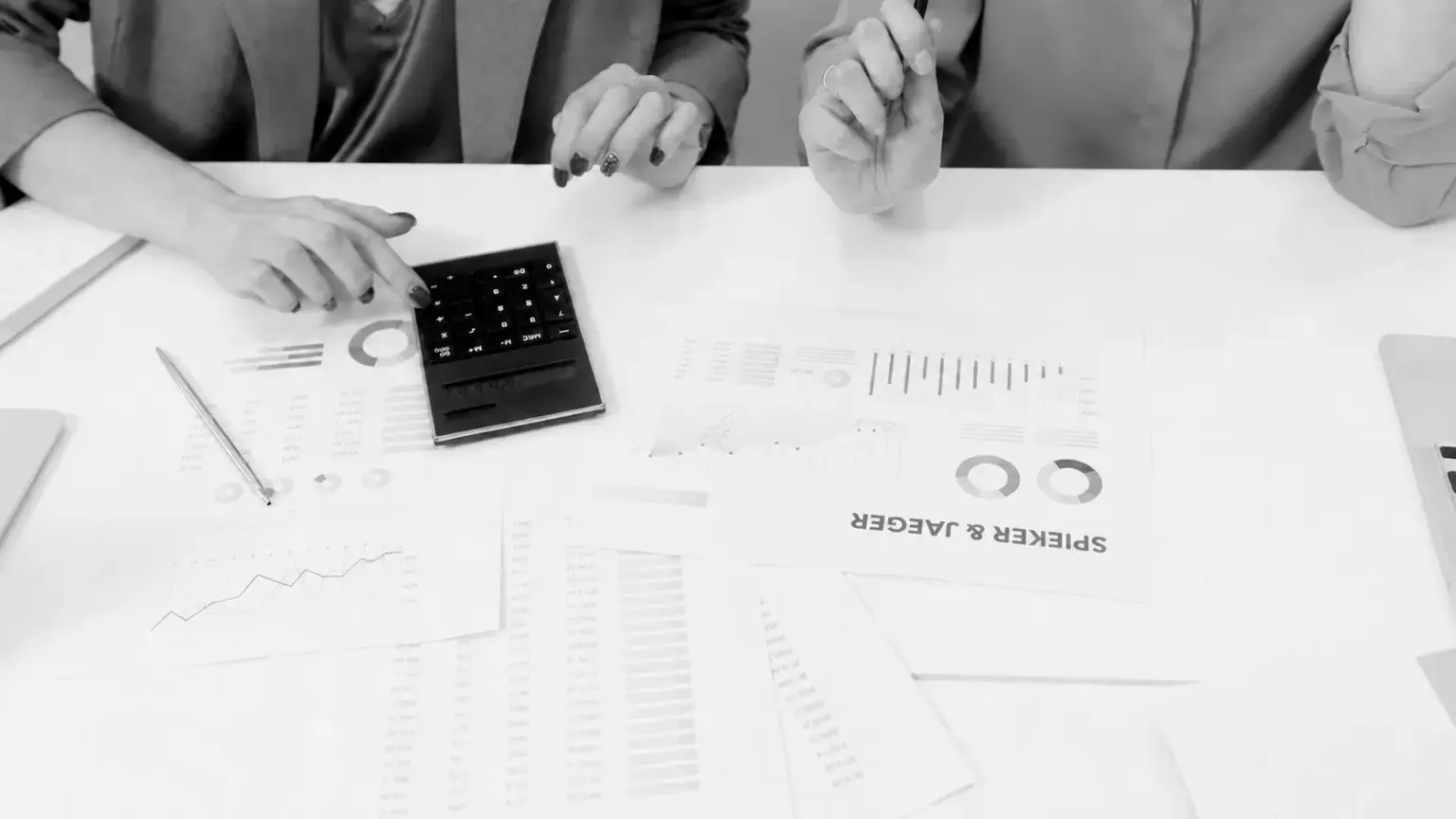 Business team reviewing financial charts with calculator