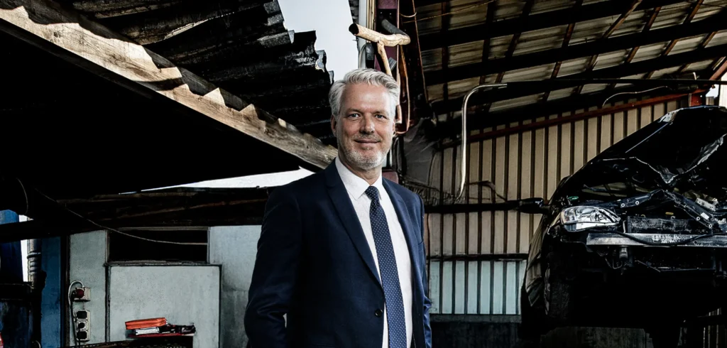 Mann in Anzug steht in Werkstatt.