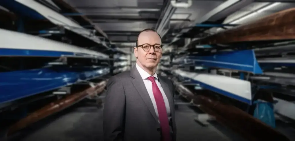 Mann in Anzug zwischen Ruderbooten