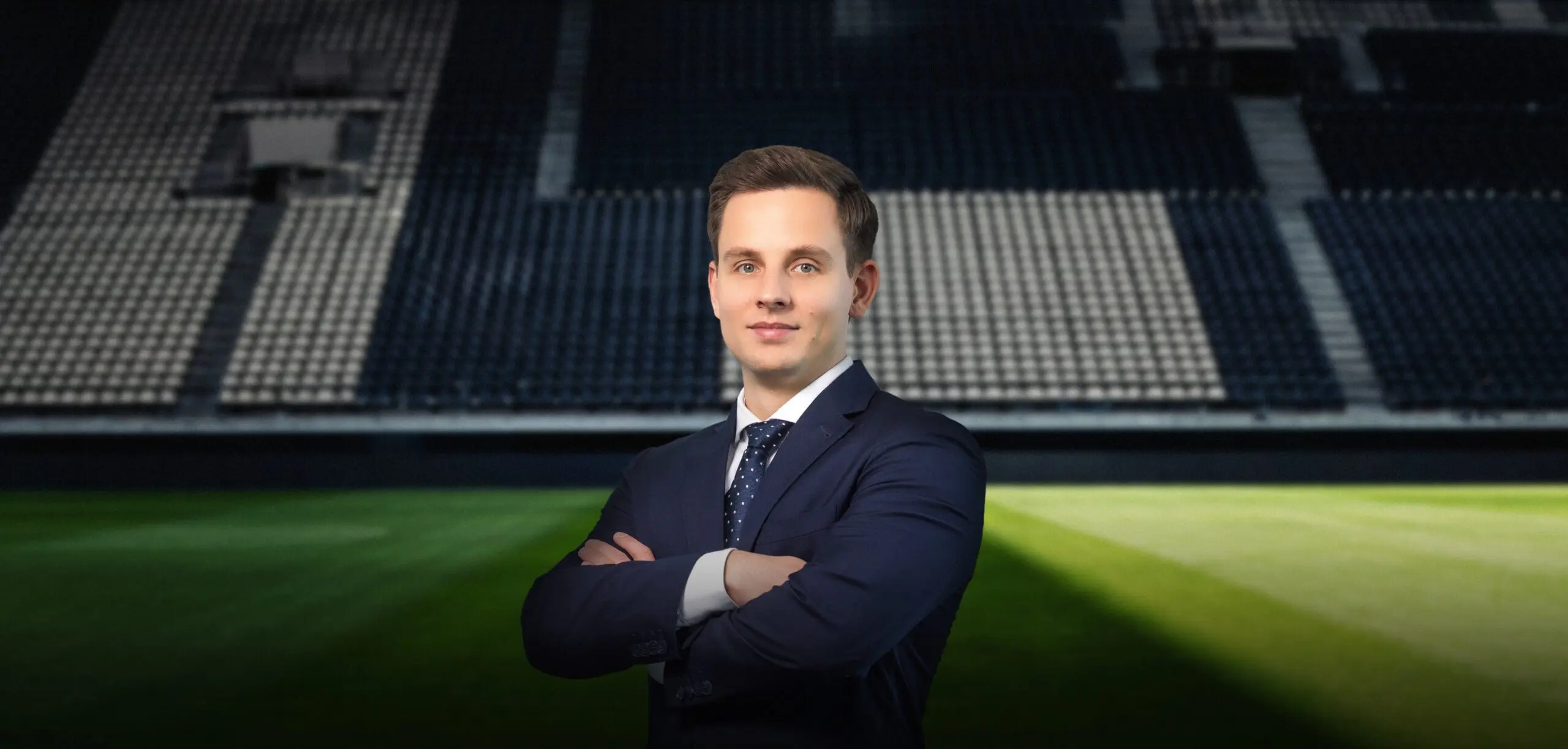 Mann in Anzug vor einem leeren Stadion