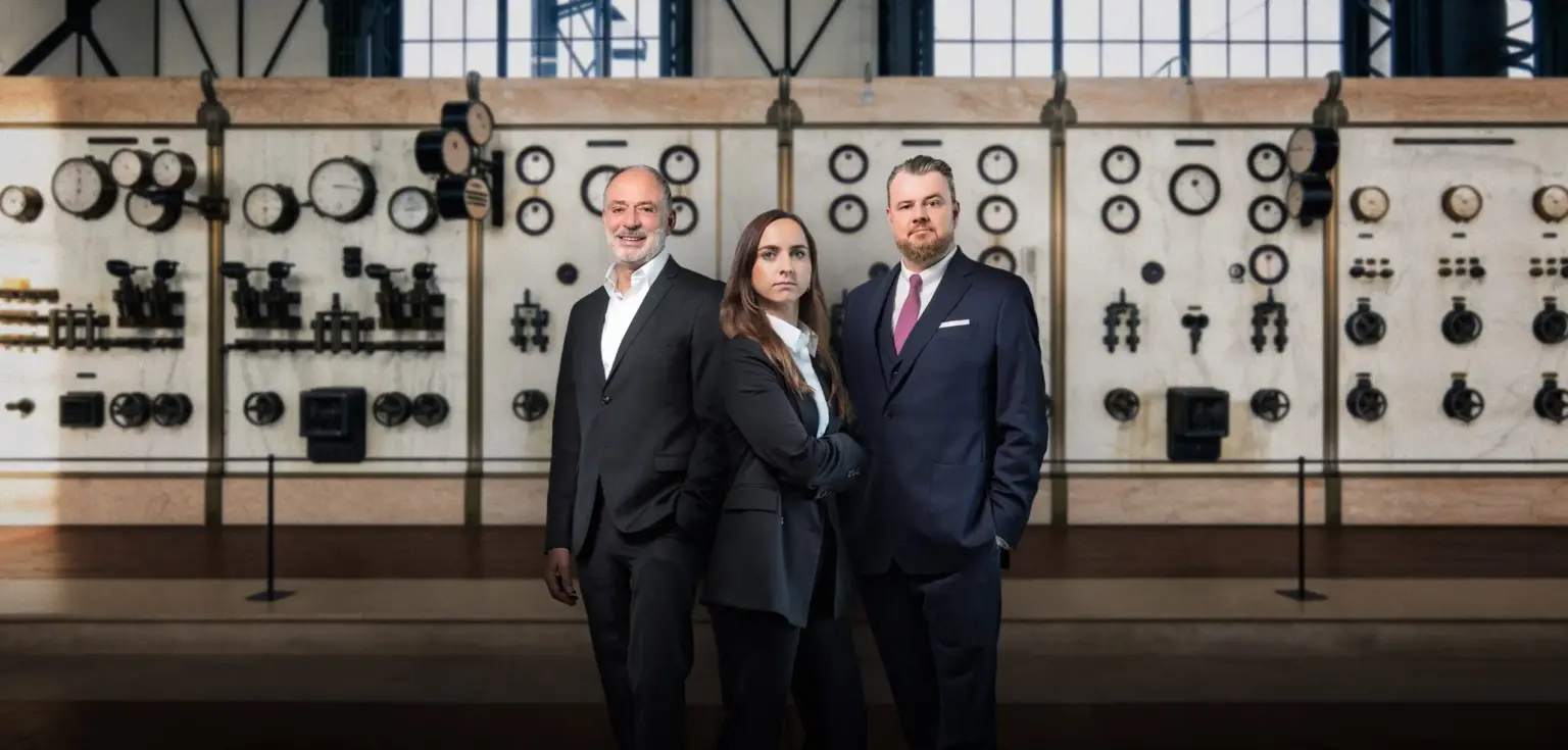 Drei Personen vor einem Bedienfeld