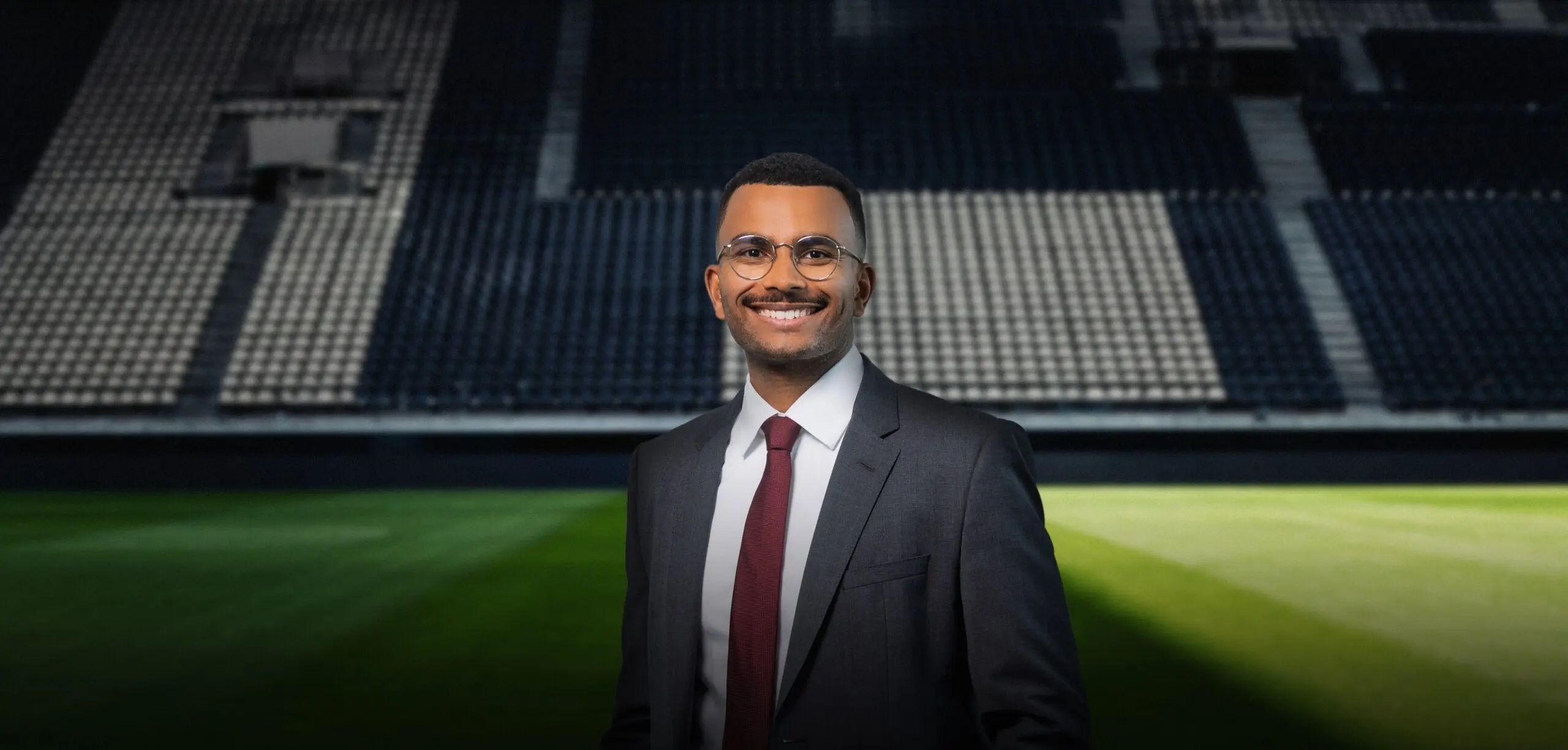 Mann im Anzug auf einem Fußballfeld