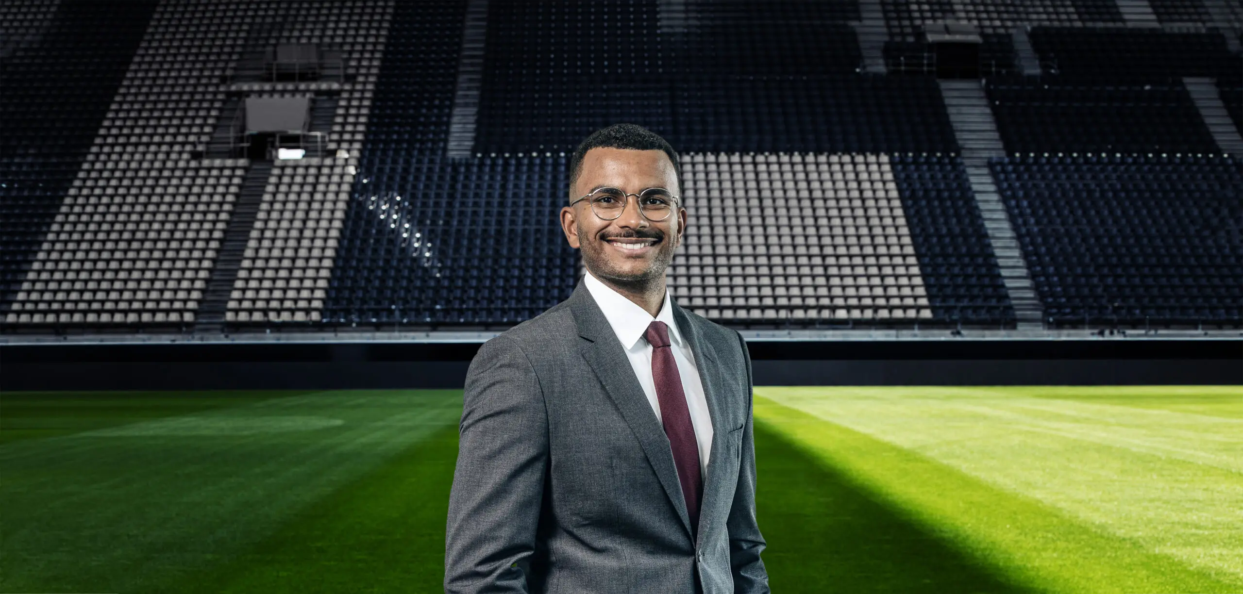 Mann im Anzug vor leerem Stadion