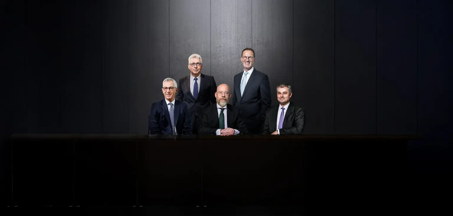 Fünf Personen sitzen an einem Tisch.