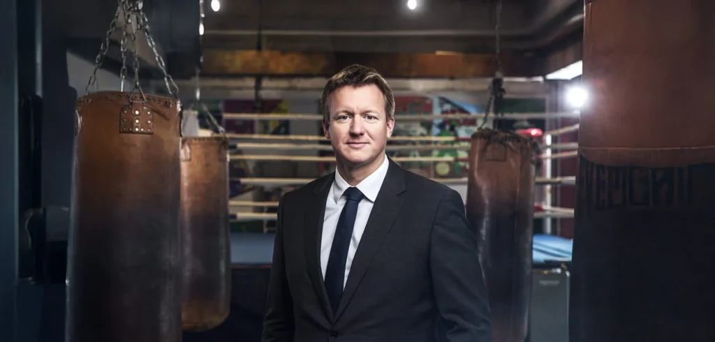 Mann vor Boxsäcken in einem Fitnessstudio.